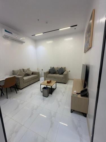 ein Wohnzimmer mit zwei Sofas und einem Fernseher in der Unterkunft سكوت Scoott in Dschāzān