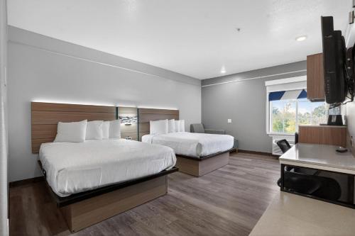 a hotel room with two beds and a kitchen at Sonesta Essential Hotel Houston-I-45 Spring in Houston