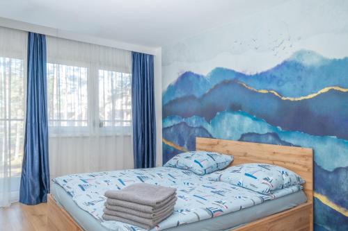 a bedroom with a mountain mural on the wall at Nadmorski Bursztyn - Błękitna in Rowy