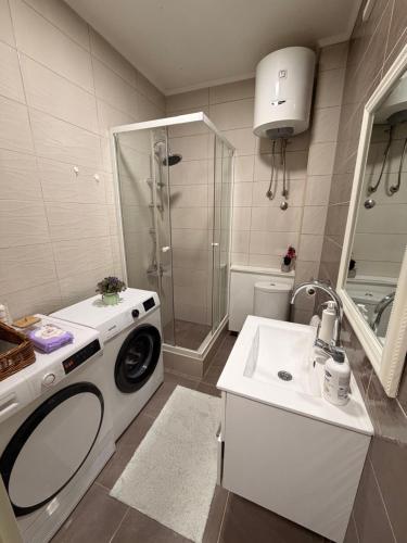a bathroom with a washing machine and a sink at Apartman Maja in Prijedor