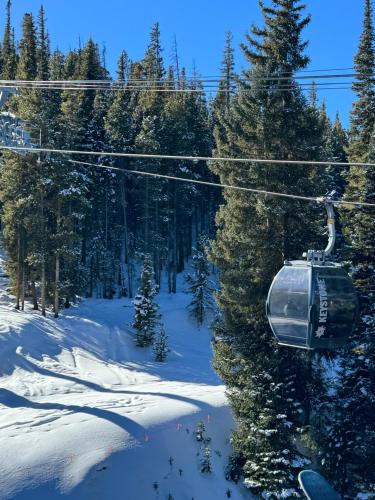 a ski lift in the snow with snow covered trees at Quicksilver 1605 by SummitCove Lodging in Colorado in Keystone
