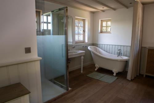 a bathroom with a tub and a shower and a sink at Vakantiehuis Lisette in Veurne