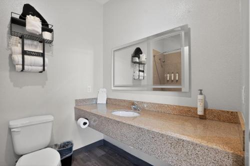 a bathroom with a sink and a toilet and a mirror at Sonesta Essential Hotel Houston-I-45 Spring in Houston