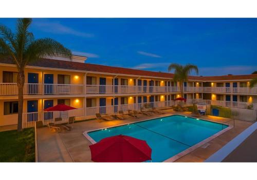 a pool in front of a hotel at night at Motel 6-Carlsbad, CA Beach in Carlsbad