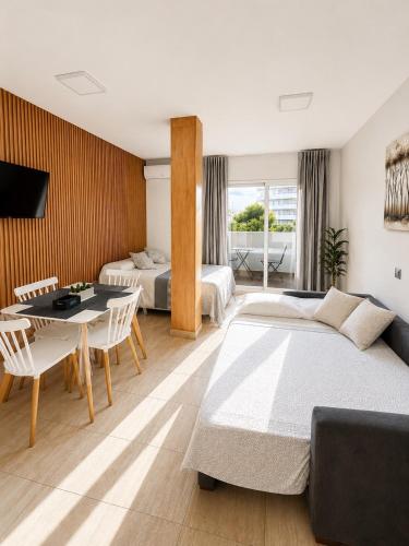 a bedroom with two beds and a table and chairs at Benalbeach loft in Benalmádena