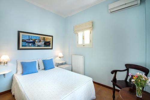 a blue bedroom with a bed and a table at Villa Ersilia in Egina