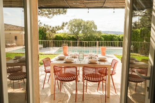 a table and chairs on a patio with a pool at Casa Mamou in Cavaillon