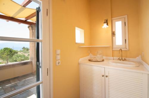 a bathroom with a sink and a mirror and a window at Villa Ersilia in Egina