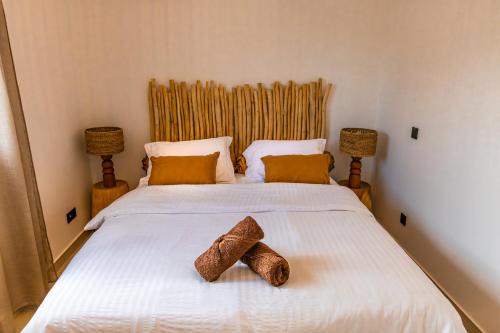 a bedroom with a bed with two towels on it at Les Clos de L Albatros in Saint-Paul
