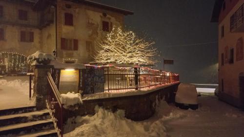 a house with a christmas tree in the snow at Albergo Coira Antica Dimora in Santa Brigida