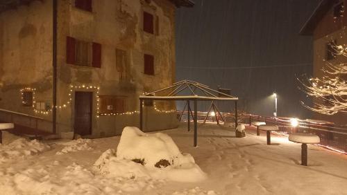 a playground covered in snow in front of a building at Albergo Coira Antica Dimora in Santa Brigida