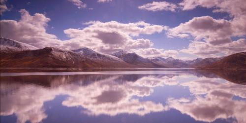 a reflection of mountains in the water with clouds at Corriegour Lodge Hotel in Spean Bridge