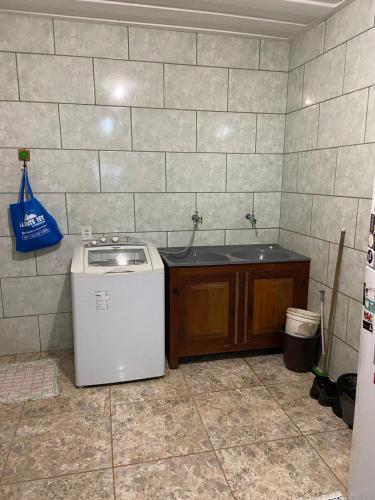 a laundry room with a washer and a counter at Quartos em Tiradentes MG - A Casa Sarará in Tiradentes