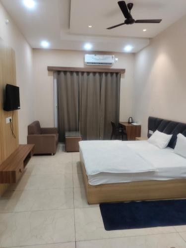 a bedroom with a bed and a couch and a ceiling at Kanti empire in Dhaulpur
