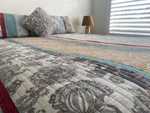 a bedroom with a bed with a quilt on it at Huntlee Getaway in Branxton