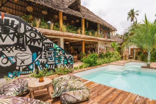 ein Resort mit Schwimmbad und einem Gebäude in der Unterkunft Oke Ani Boutique Hotel in Paje