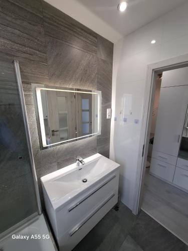 a bathroom with a white sink and a mirror at Lomnica Lodge in Vysoké Tatry