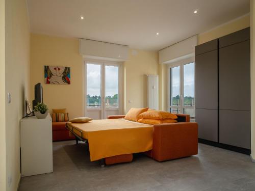 a bedroom with a bed with orange pillows on it at Testa tra le Nuvole - Attico con Terrazza panoramica in centro in Novi Ligure