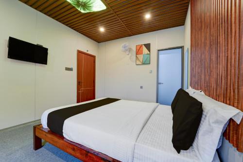 a bedroom with a large bed and a television at Super Hotel O AM Grandd in Kāraikkudi