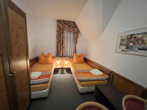 a small room with two beds and a window at Attikos Hotel & Restaurant in Lengenfeld