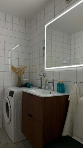 a bathroom with a sink and a washing machine at Charming room central Oslo in Oslo