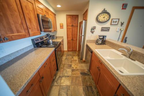 a kitchen with wooden cabinets and a sink at Pines 2147 by SummitCove Lodging in Colorado in Keystone