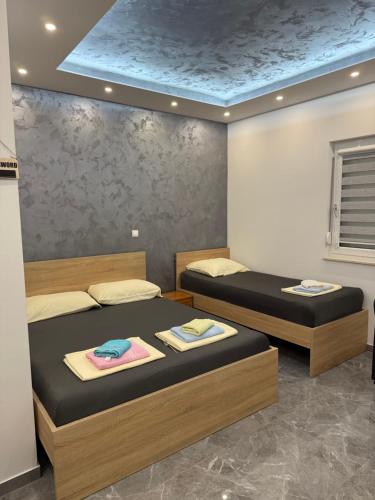 two beds in a room with towels on them at Apartmani Filip in Podaca