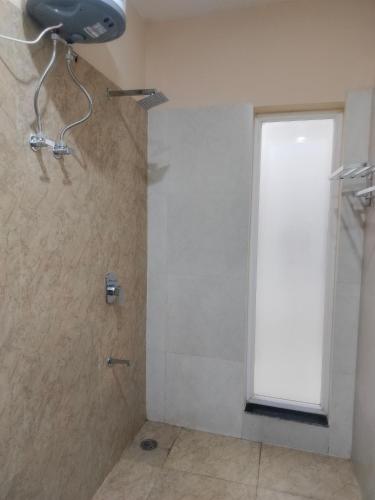 a shower in a bathroom with a window at Kanti empire in Dhaulpur