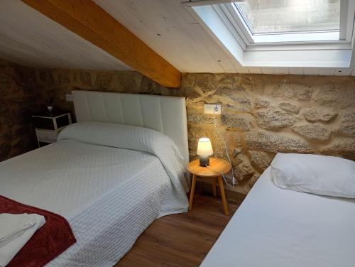 a bedroom with two beds and a window at Casa rústica busto in Armentera