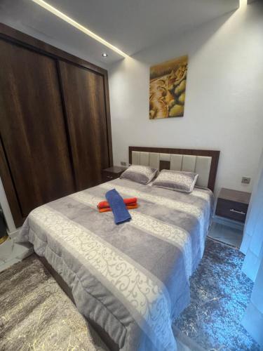 a bedroom with a bed with a blue ribbon on it at Mehdia plage in Kenitra