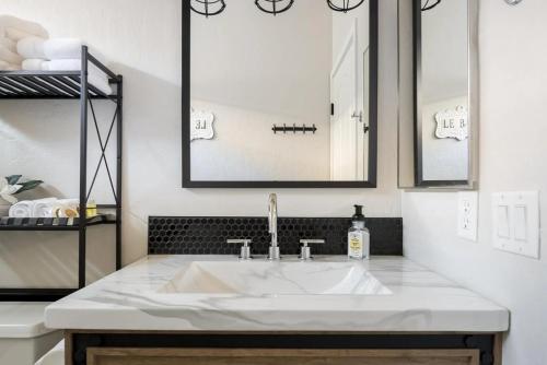 ein Badezimmer mit einem weißen Waschbecken und zwei Spiegeln in der Unterkunft Gilbert Laurel in Gilbert
