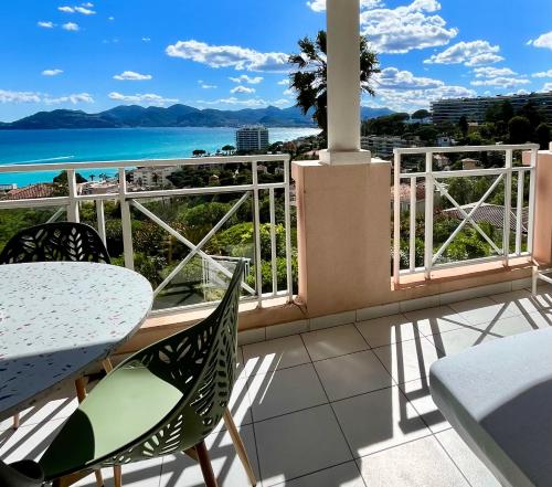 a balcony with a table and chairs and the ocean at Splendid view Apartment in Cannes in Cannes