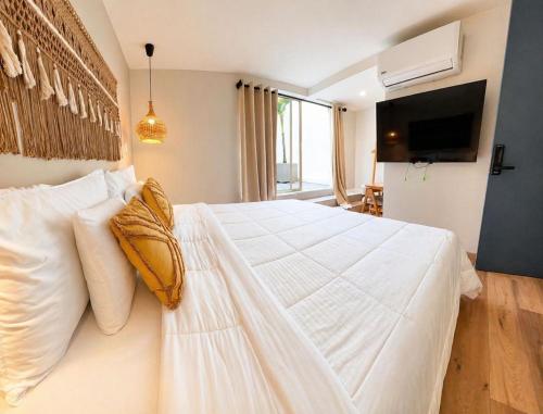 a bedroom with a large white bed with white pillows at Poblado Luum Boutique hotel in Medellín