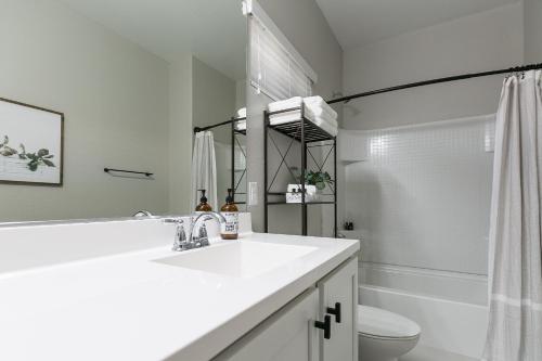 a white bathroom with a sink and a toilet at Mesa Palms Ferro in Mesa