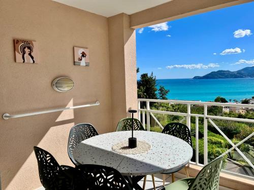 a table and chairs on a balcony with a view of the ocean at Splendid view Apartment in Cannes in Cannes