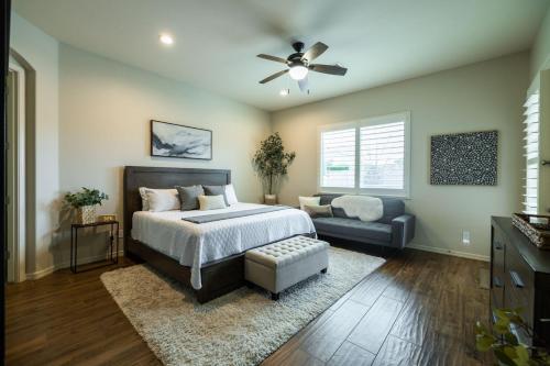 a bedroom with a bed and a couch and a ceiling fan at Queen Creek on 193rd in Queen Creek