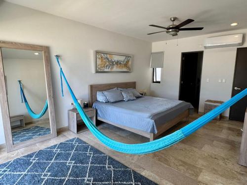 ein Bett mit einer blauen Hängematte in einem Schlafzimmer in der Unterkunft Telchac Ocean Suite in Xtampú