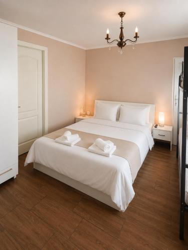a bedroom with a large white bed with two towels at Casa Andra in Drobeta-Turnu Severin