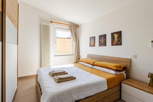 a bedroom with a bed with towels on it at Dimora Sant Anna in Piacenza