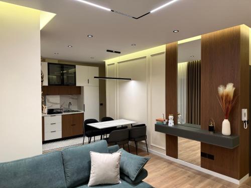 a living room with a blue couch and a kitchen at Modern Luxury Apartment-City Center-Walk Anywhere in Durrës