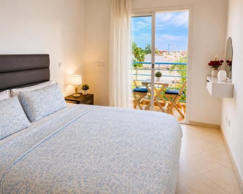 a bedroom with a bed and a balcony with a view at Cozy Studio Near Beach with Pool Access in Martil