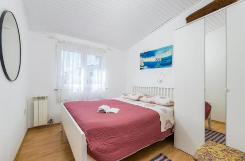 a white bedroom with a bed with a pink blanket at Garden House Premantura in Premantura