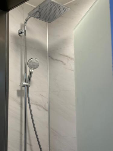 a shower with a shower head in a bathroom at WELTRAD Parkhotel am Fluss in Schönebeck