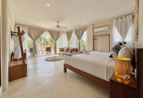 a bedroom with a large bed and a living room at Noah Beach Hotel & Suites in Mahahual