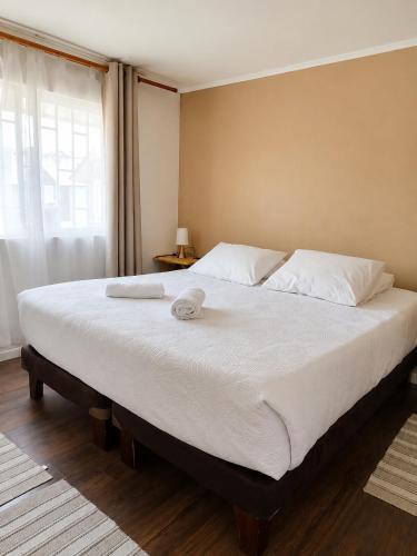a large bed with two towels on top of it at Tronador I in Puerto Montt