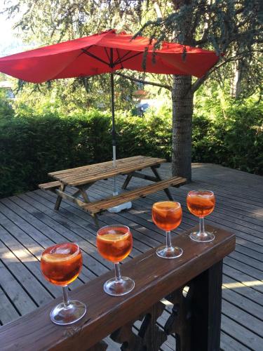 a picnic table with three wine glasses and an umbrella at Chalet Yuki in Morzine