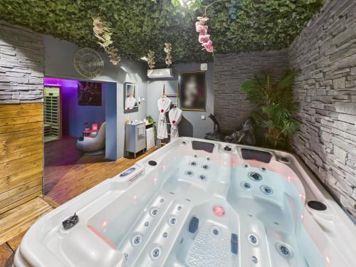 a large white bath tub in a room at L'instant secret in Berlaimont