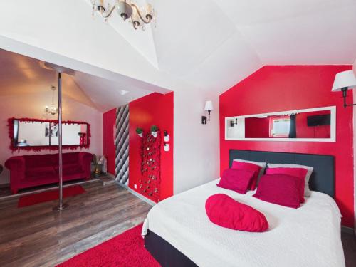 a bedroom with red walls and a bed with red pillows at L'instant secret in Berlaimont