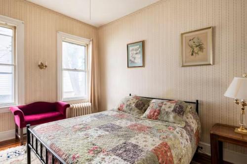 a bedroom with a bed and a red chair at Cozy Cape Cod Bungalow King Queen WD Full Kitchen Wifi Desk in York