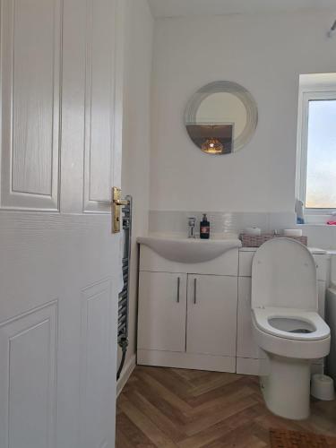 a white bathroom with a toilet and a sink at Modern living in Hull in Hull